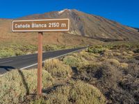 the sign points to a road and some bushes near a mountain with the words canada blanca