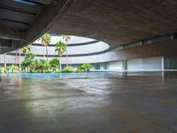 the concrete ground in front of an atrium building with a round roof on one side