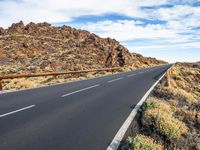 a paved mountain road with no cars on it in the desert on a sunny day