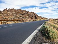 a paved mountain road with no cars on it in the desert on a sunny day