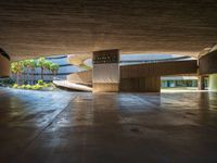 a large concrete building with a parking space and multiple staircases down the middle of it