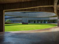 large circular roofed building with a grassy lawn outside of it that looks like an atrium