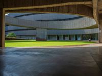 large circular roofed building with a grassy lawn outside of it that looks like an atrium