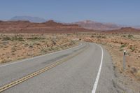 a deserted open road in the middle of a desert with no one on it to be seen