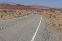 a deserted open road in the middle of a desert with no one on it to be seen