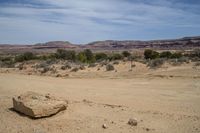 a road on a desert side with mountains in the back ground and dirt in front