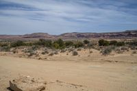 a road on a desert side with mountains in the back ground and dirt in front