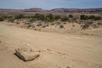 a road on a desert side with mountains in the back ground and dirt in front