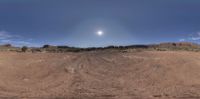 a wide shot of an intersection that shows dirt and rock formations on the ground under a blue sky and white clouds