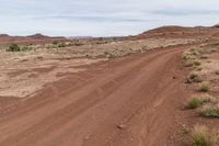 dirt road through desert with rock in the distance on sunny day outside of town in southwest colorado