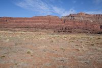 a wide empty open plain in a remote desert area near the mountain ranges and sparse grasses