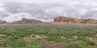 the clouds are starting to move in over the valley and rocks and grass, making a dark sky