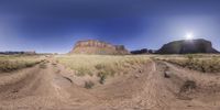 a panorama of two roads going through a desert field, one shows the path and the other has an amazing view