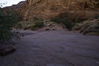 a man standing at the edge of a mountain, looking out towards a desert area