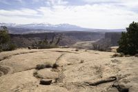 a view of some mountains with hills in the distance from a rocky ledge and valley below