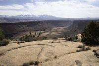 a view of some mountains with hills in the distance from a rocky ledge and valley below