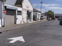 the empty street in the small town has a sign pointing to the left and right