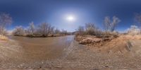 a river and a clear blue sky in a panoramic view of the desert