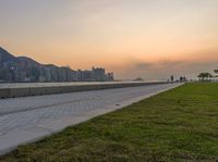 a view of a lake, and the ocean from a park bench at sunset in hong