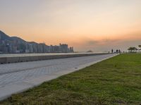 a view of a lake, and the ocean from a park bench at sunset in hong