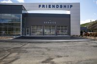 a car dealers building that has its front doors open and the words friendship above it