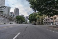 a car is traveling down an empty city street in motion with trees lining the road