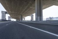 a photo from a car that is going under a freeway bridge in a city area