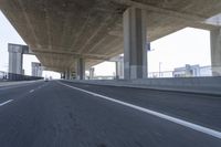 a photo from a car that is going under a freeway bridge in a city area