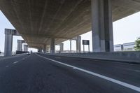 a photo from a car that is going under a freeway bridge in a city area