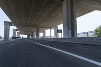 a photo from a car that is going under a freeway bridge in a city area