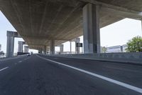 a photo from a car that is going under a freeway bridge in a city area