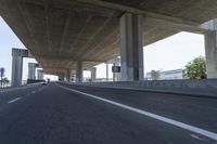 a photo from a car that is going under a freeway bridge in a city area