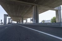 a photo from a car that is going under a freeway bridge in a city area