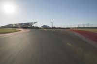 a car driving on the track in motion, at sunset time with bright sun shining