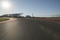 a car driving on the track in motion, at sunset time with bright sun shining