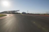 a car driving on the track in motion, at sunset time with bright sun shining