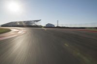 a car driving on the track in motion, at sunset time with bright sun shining