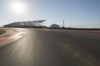 a car driving on the track in motion, at sunset time with bright sun shining