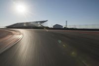 a car driving on the track in motion, at sunset time with bright sun shining