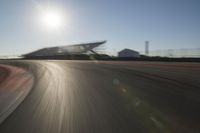 a car driving on the track in motion, at sunset time with bright sun shining