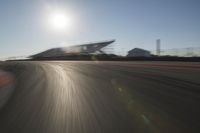 a car driving on the track in motion, at sunset time with bright sun shining