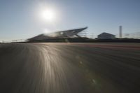 a car driving on the track in motion, at sunset time with bright sun shining