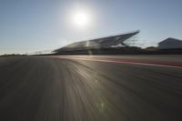 a car driving on the track in motion, at sunset time with bright sun shining