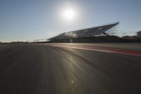 a car driving on the track in motion, at sunset time with bright sun shining