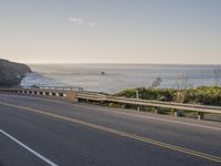 a car on the road near the ocean in the daytime light of day and the sun