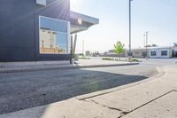 a car parked in the street near some stores is reflecting the sun through a window