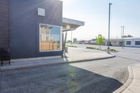 a car parked in the street near some stores is reflecting the sun through a window