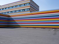 a car parked in front of a multicolored building in a parking lot outside