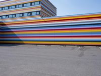 a car parked in front of a multicolored building in a parking lot outside