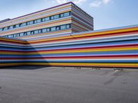 a car parked in front of a multicolored building in a parking lot outside